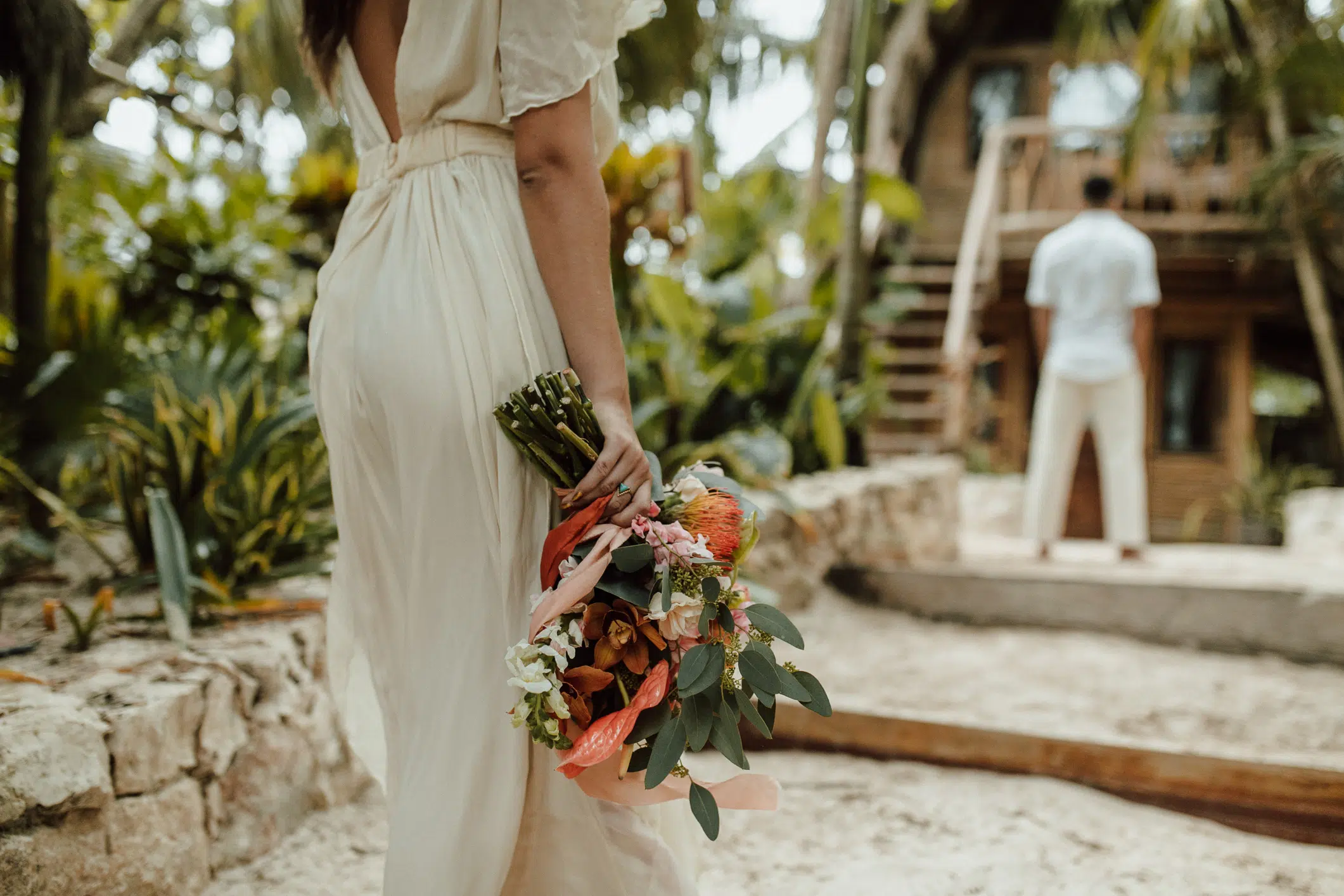 Novia sosteniendo un ramo tropical en el jardín de la selva