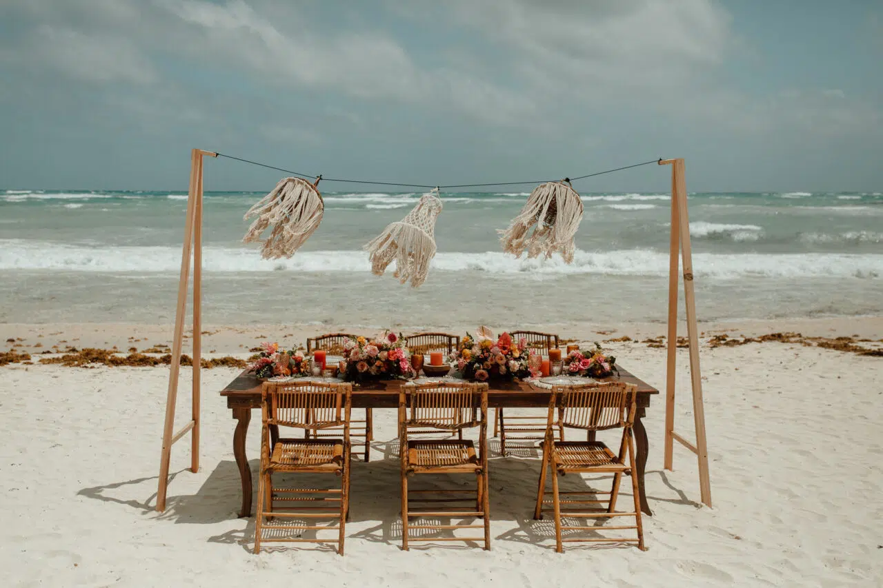 Mesa frente al mar con colgantes de macramé y el mar de fondo
